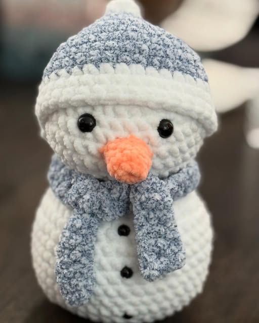 Crochet snowman with a grey hat and scarf